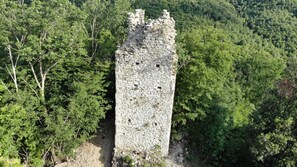 A stone tower surrounded by dense forest. - Il Borgo Incantato Dependance (Spoleto)