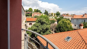 A terrace with red-tiled roofs, a view of a town with buildings and trees, and a clear sky. - Luxury apartment Vivaldi - Two bedroom apartment (Pula)