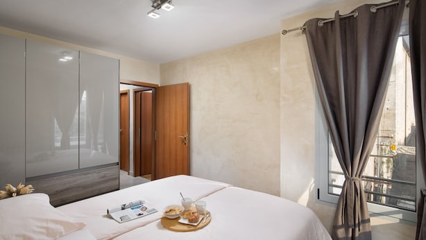 A hotel room with a bed, a breakfast tray, a wardrobe, and a window with curtains. - Luxury apartment Vivaldi - Two bedroom apartment (Pula)