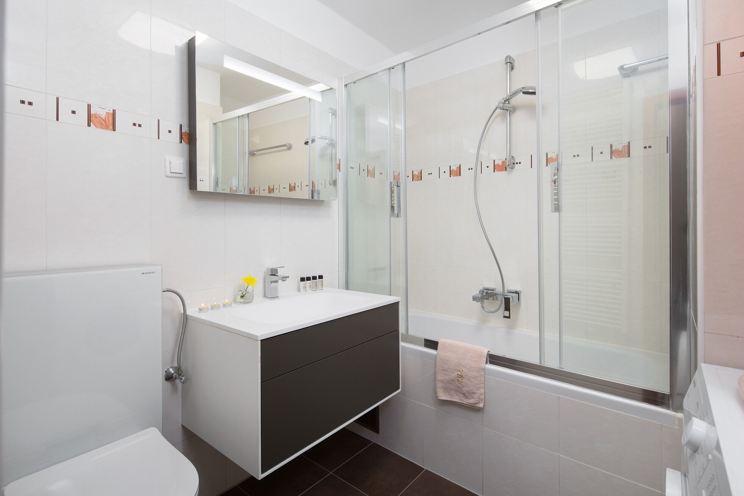 Un bagno moderno con un mobile bagno bianco, una cabina doccia in vetro e una vasca.