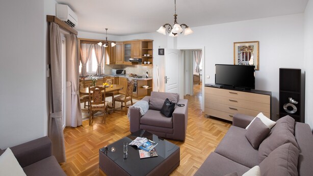 A modern living room with a sofa, a coffee table, and a television.