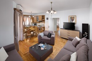 Un salon moderne avec un canapé, une table basse et un téléviseur.