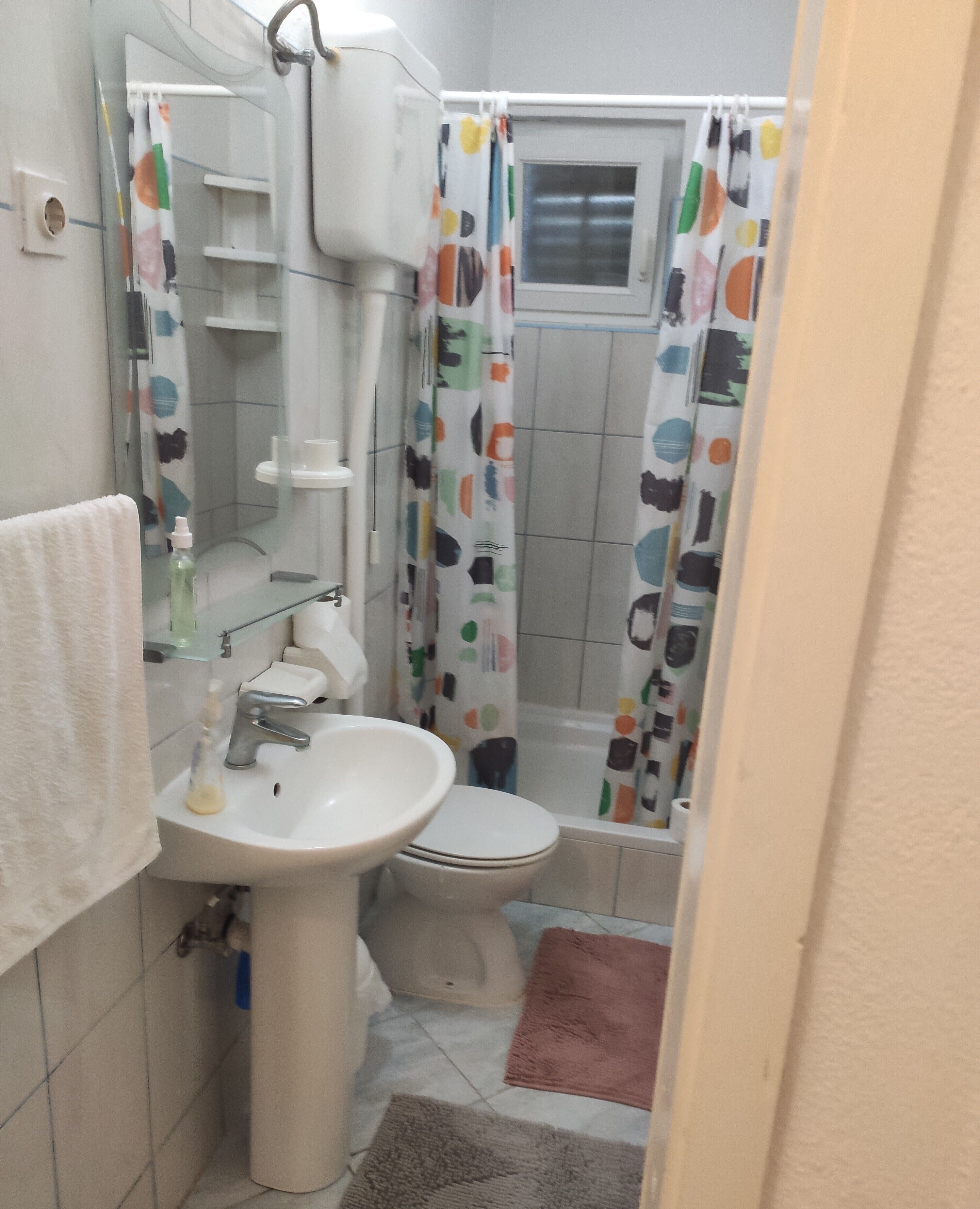 A bathroom with a sink, toilet, and shower curtain.