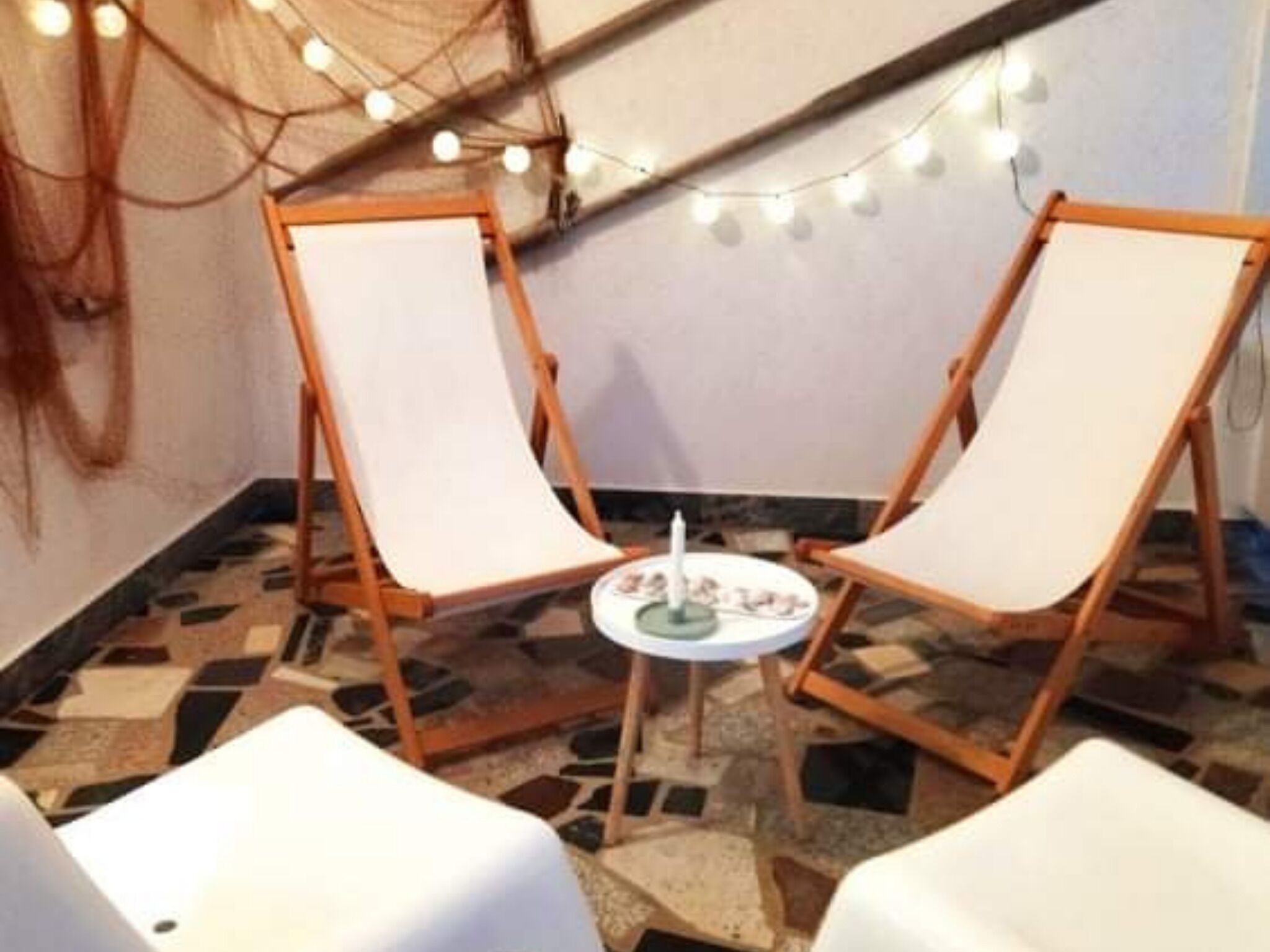 Ein Zimmer mit zwei Staffeleien und einem kleinen Tisch mit Kerze, auf gefliestem Boden.