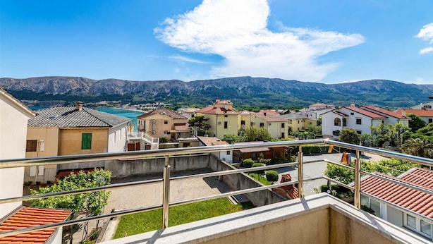 A residential area with terraced houses, a clear sky, and mountains in the background. - Nikolina B1 - Charming 2-Bedroom Haven for Four, Pet-Friendly with Parking (Baška)