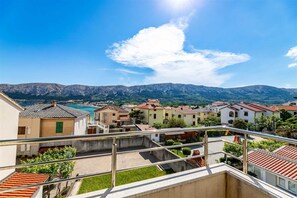 Zona residencial com casas em socalcos, céu limpo e montanhas ao fundo.