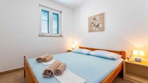A bedroom with a bed, two bedside lamps, a window with shutters, and a wall-mounted artwork. - Nikolina B1 - Charming 2-Bedroom Haven for Four, Pet-Friendly with Parking (Baška)