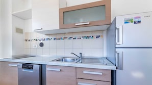 A modern kitchen with a built-in dishwasher, stainless steel refrigerator, and a colorful backsplash. - Nikolina B1 - Charming 2-Bedroom Haven for Four, Pet-Friendly with Parking (Baška)