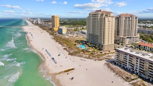 Un paisaje urbano costero con una playa, edificios altos y cielo despejado.