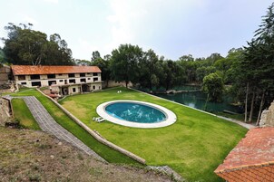 Una piscina al aire libre, sillones reclinables de piscina