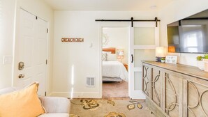 A modern bedroom with a bed, bedside table, and a TV mounted on the wall. - Fried Egg Flat (Moscow)