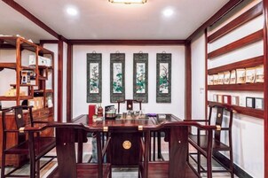 Un comedor tradicional con una mesa y sillas de madera, cuadros en la pared y una estantería.