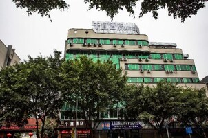 Un edificio de varios pisos con fachada plana, ventanas amplias y un letrero en la parte superior.