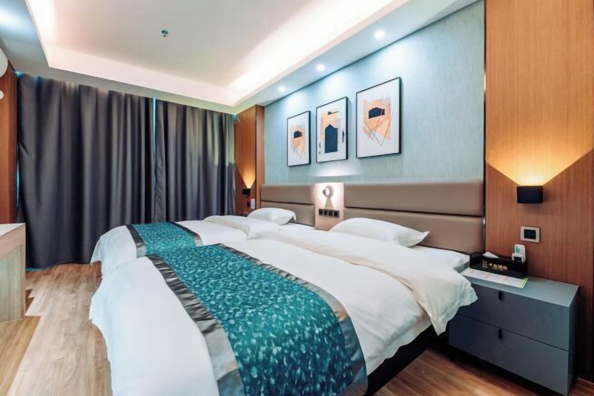 Habitación de hotel con una cama grande, una mesita de noche y una lámpara de pared.