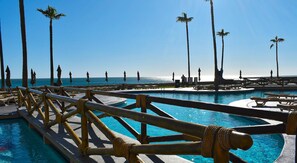 Alberca al aire libre, sombrillas en la alberca y camastros