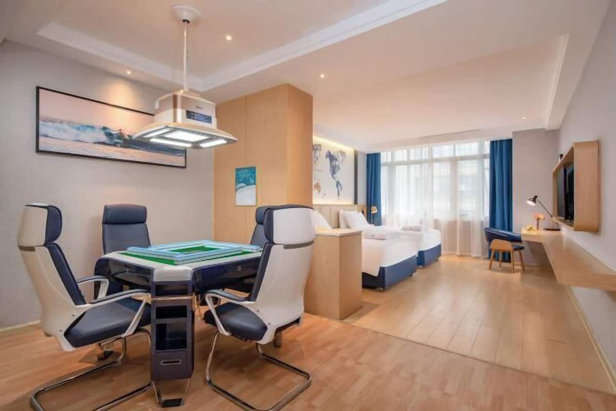 Una camera d'albergo moderna con zona pranzo, un letto e una scrivania.