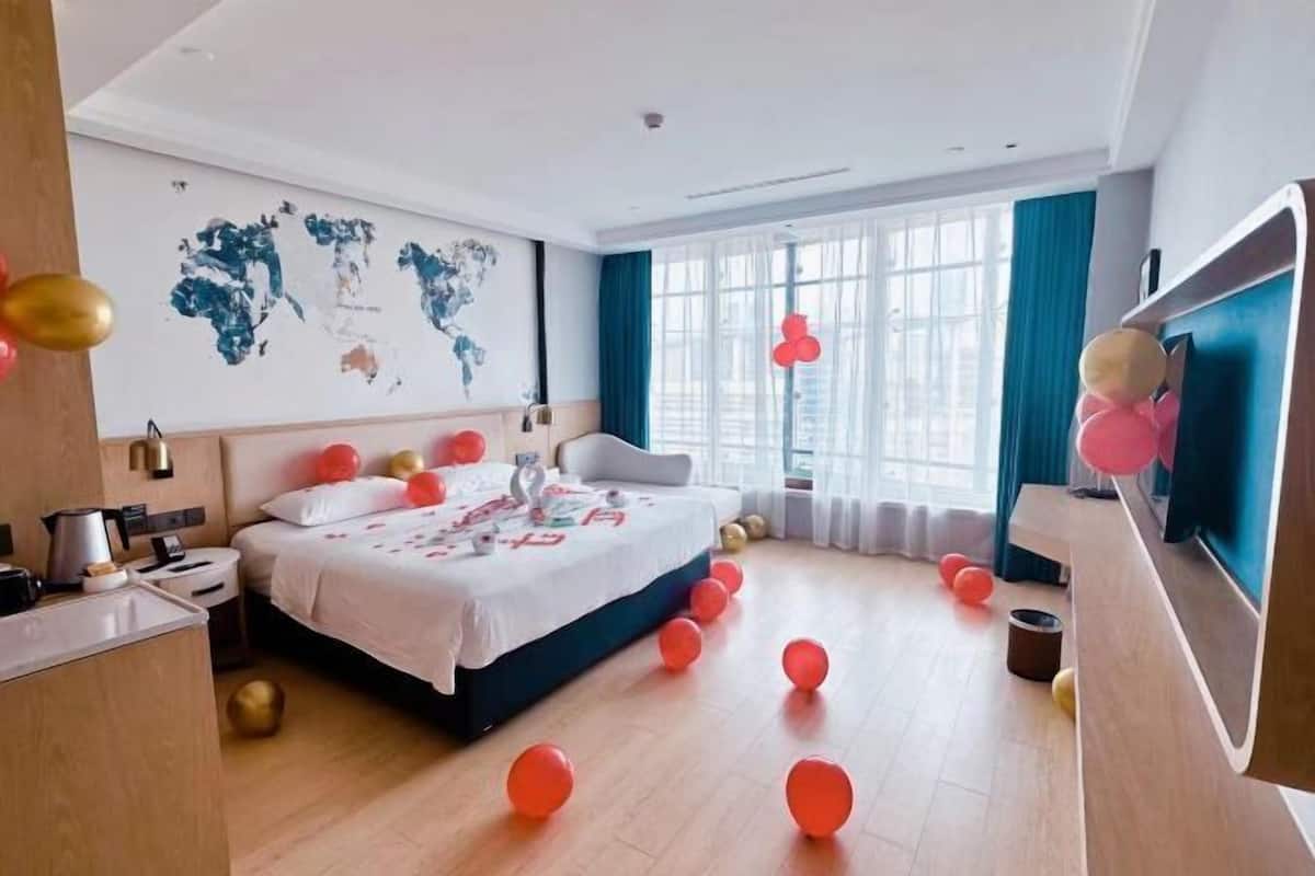 Una moderna camera d'hotel con un letto grande, una mappa del mondo appesa al muro e un'ampia finestra con tende.