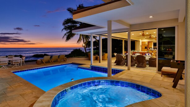 A modern outdoor pool area with a hot tub, lounge chairs, and a view of the ocean at sunset. - Luxury Oceanfront Private Estate, large family gatherings (Kailua-Kona)