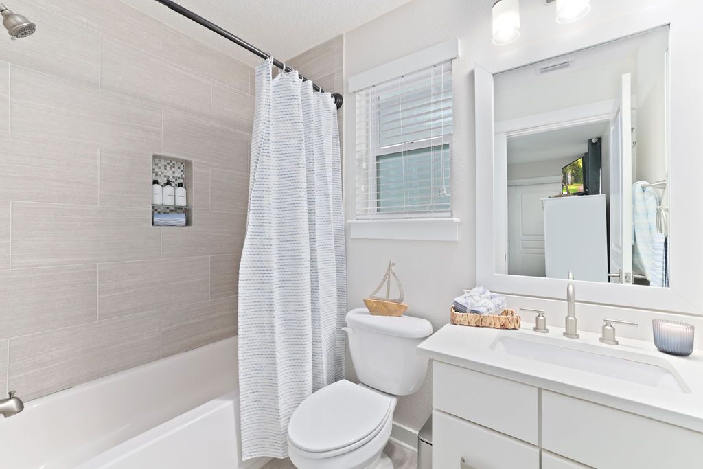 A modern bathroom with a shower, toilet, and sink.
