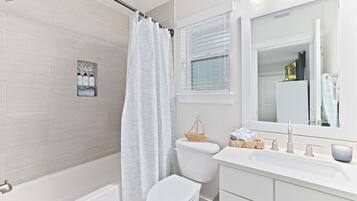 A modern bathroom with a shower, toilet, and sink.