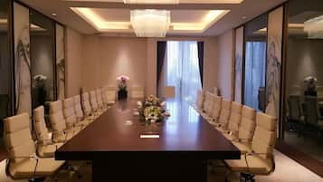 A conference room with a long table, chairs, and a chandelier.