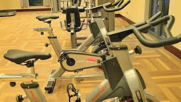 A row of stationary bikes in a room with a patterned floor.