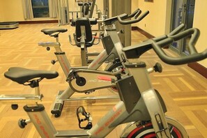 Varias bicicletas estáticas en una sala con piso estampado.