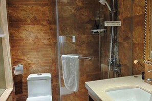 A bathroom with a glass-enclosed shower, a toilet, and a sink. - Yinlai Hotel (Xuanhan)