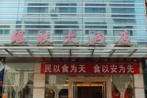 A hotel with a large sign in Chinese characters above the entrance.