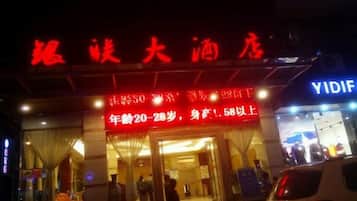 A hotel with a red signboard and a visible entrance.