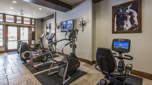Un gimnasio con cintas de correr, bicicletas estáticas y máquinas elípticas.