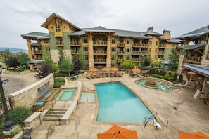 A hotel with multiple pools, outdoor seating, and a large building with balconies.