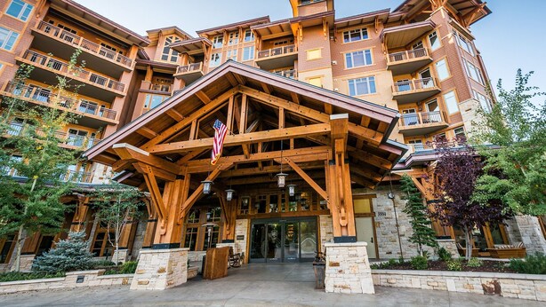 Un hotel de varios pisos con una entrada de madera llamativa y balcones.