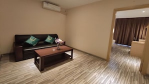 A modern living room with a sofa, coffee table, and an air conditioning unit on the wall. - City Comfort Inn (Jingdezhen Xinchang Road Taoxichuan) (Jingdezhen)
