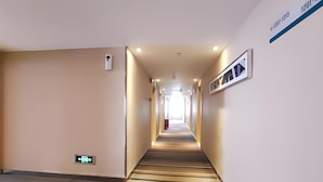 A hotel hallway with a carpeted floor, a fire alarm, and a sign indicating room number 1201. - City Comfort Inn (Jingdezhen Xinchang Road Taoxichuan) (Jingdezhen)