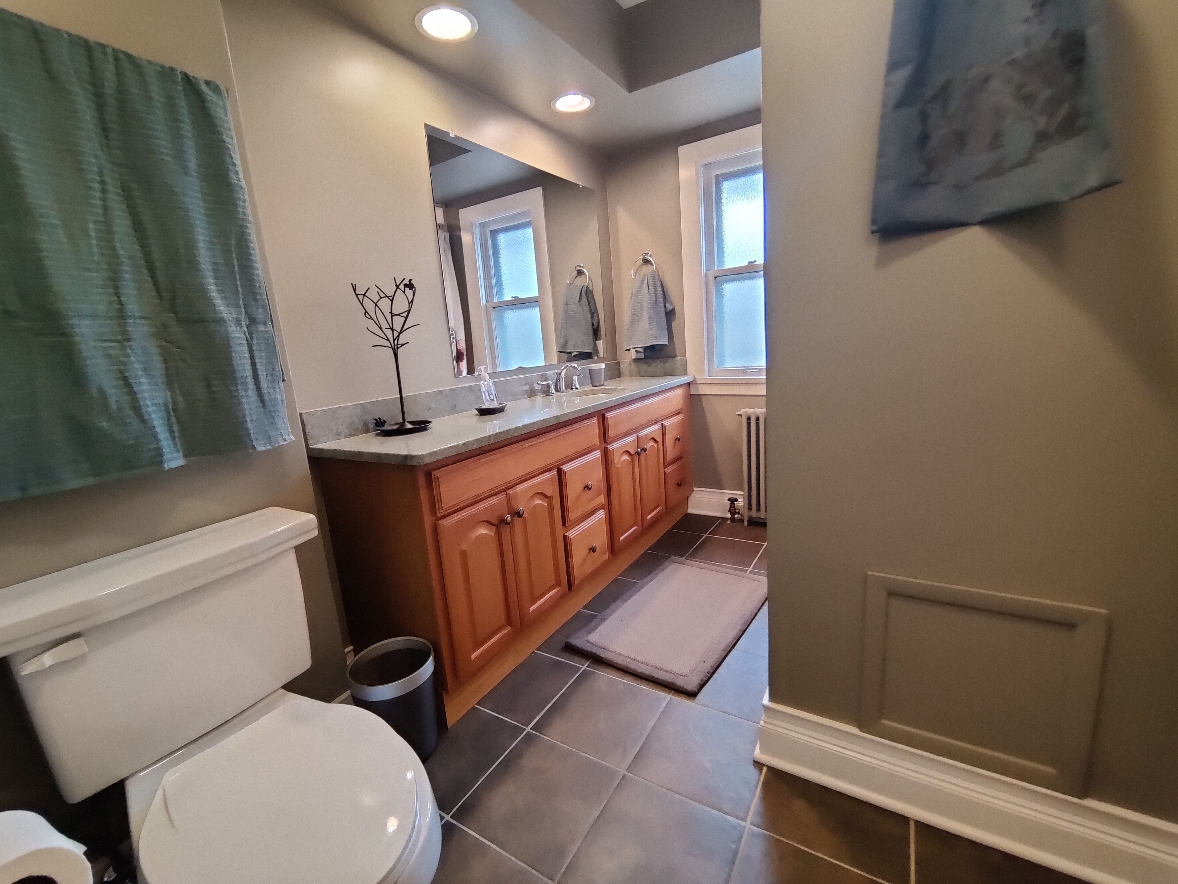 Une salle de bain avec des toilettes, un lavabo et un miroir.