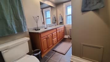 Une salle de bain avec des toilettes, un lavabo et un miroir.