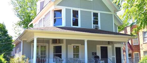 A two-story house with a front porch, a chimney, and a well-maintained lawn.