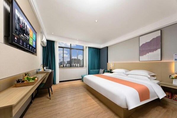 A hotel room with a bed, desk, chair, and a window with a city view.