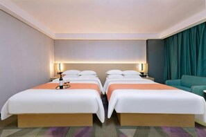 A hotel room with two beds, a sofa, and a large window.