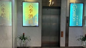 A hotel entrance with a marble floor, an elevator, and two potted plants. - Yunji Hotel (Guangzhou Olympic Sports Center Dongpu Metro Station Branch) (Guangzhou)