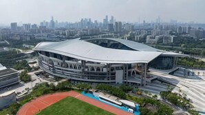 A stadium with a unique curved roof, surrounded by a cityscape. - Yunji Hotel (Guangzhou Olympic Sports Center Dongpu Metro Station Branch) (Guangzhou)