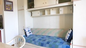 Ein Zimmer mit einem Bett, einem Sessel und Schränken.