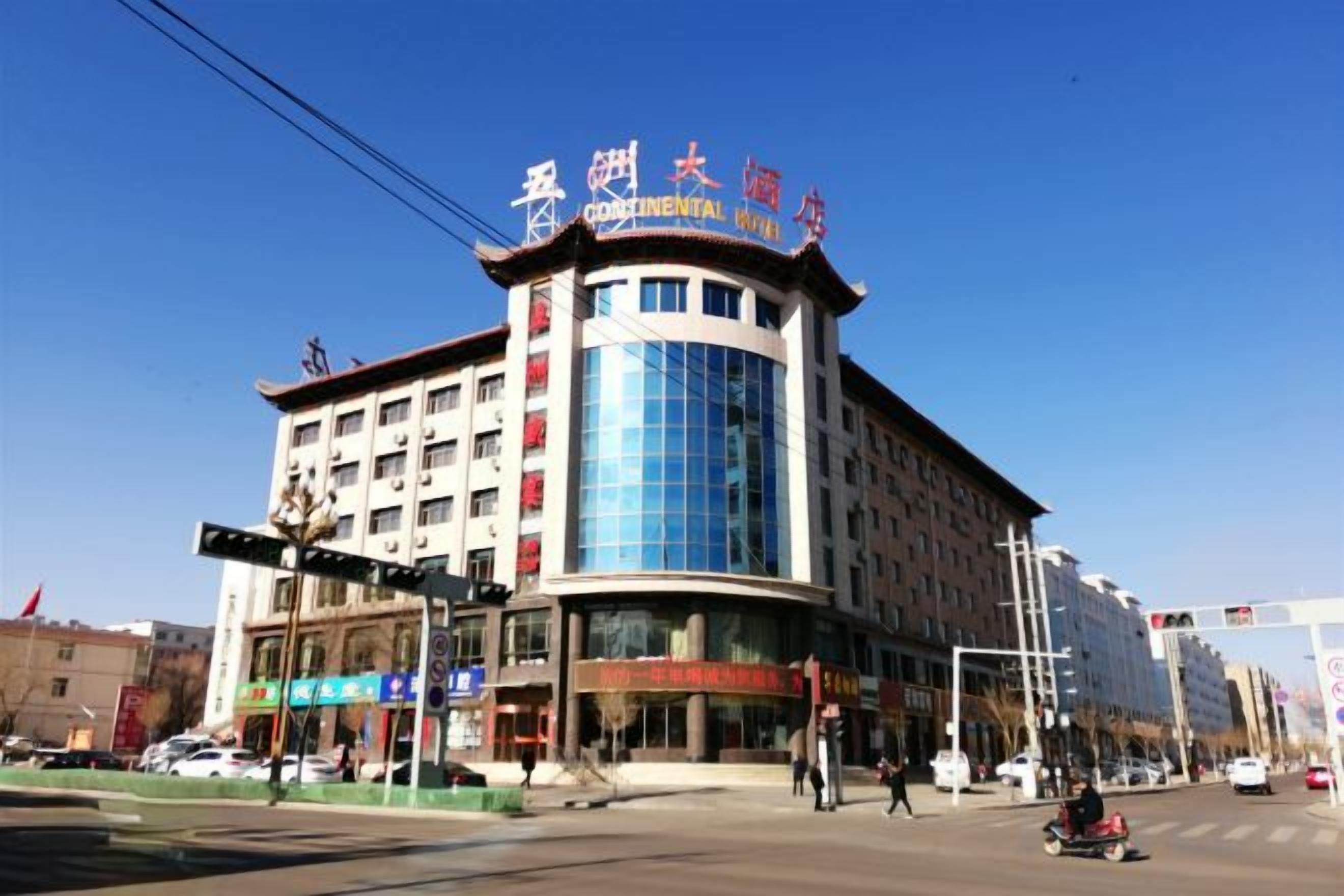 A multi-story hotel with a curved facade, large glass windows, and signage indicating it is a Continental Hotel.