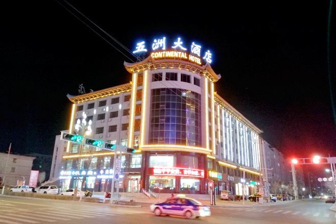A multi-story hotel with illuminated signage, a prominent entrance, and a large glass facade.