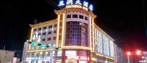 A multi-story hotel with illuminated signage, a prominent entrance, and a large glass facade.