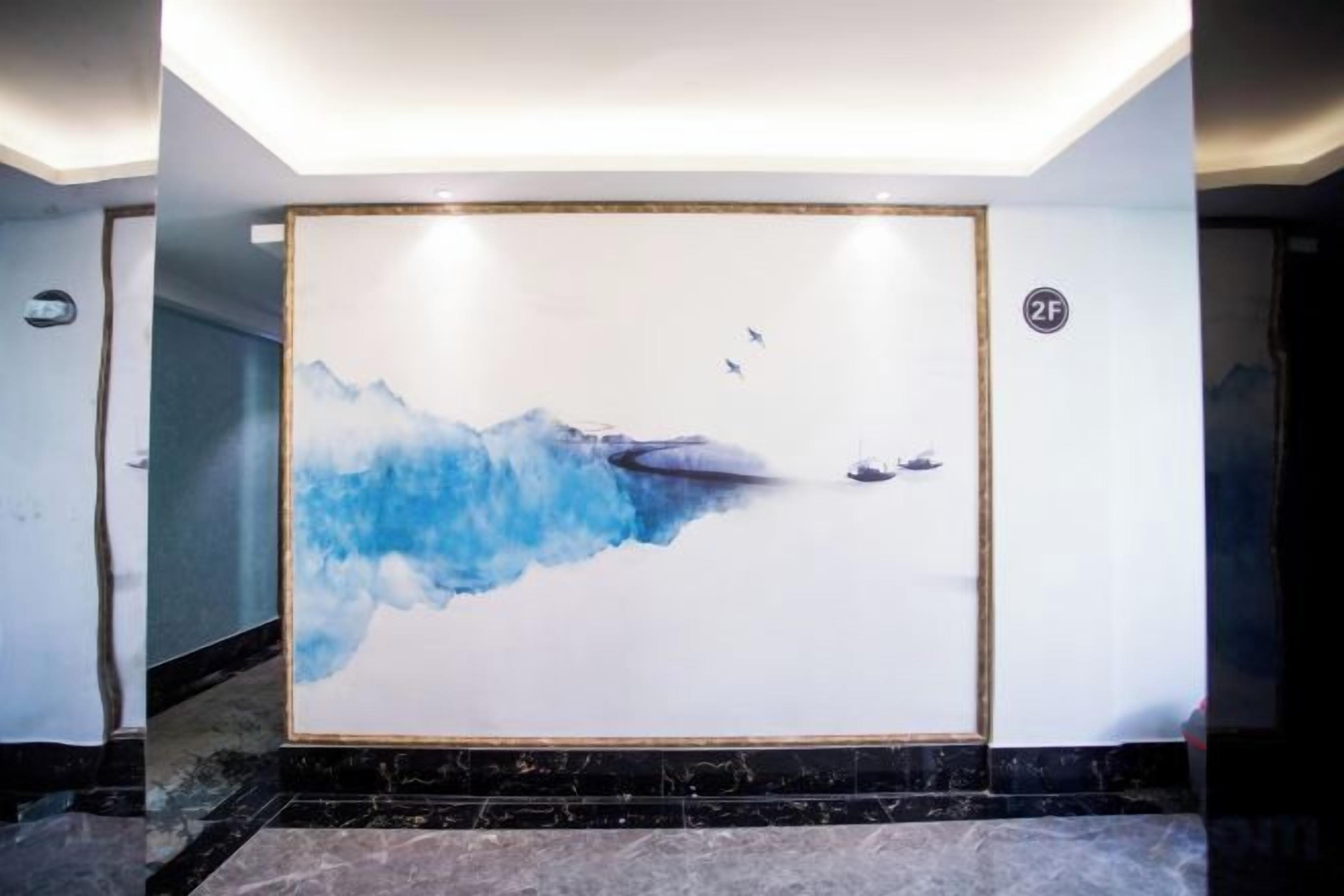 Un pasillo con un amplio mural que representa un paisaje abstracto en tonos azules.