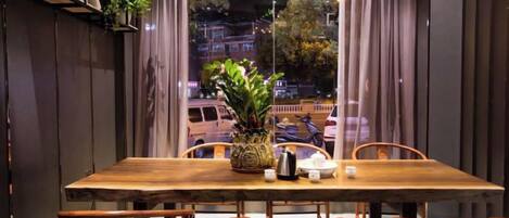 Una mesa de comedor de madera con sillas, una planta en maceta y un florero.
