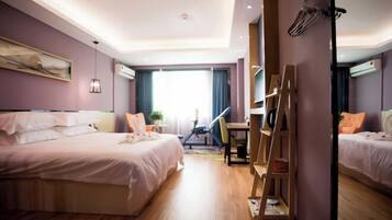 Une chambre d’hôtel avec un lit, un bureau, une chaise et une échelle.