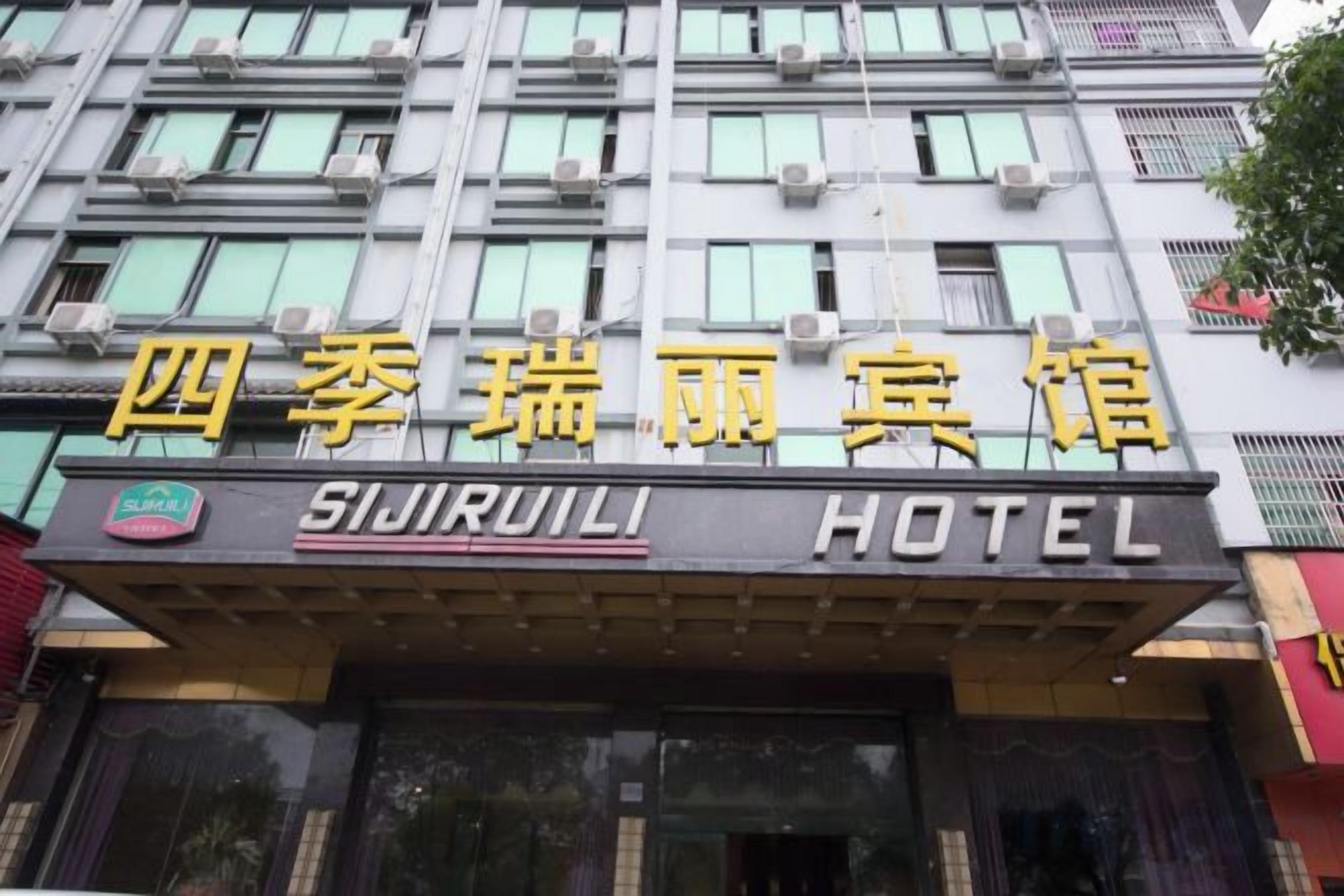 Un cartel de hotel con el nombre 'SIJIRULI HOTEL' en inglés y caracteres chinos.